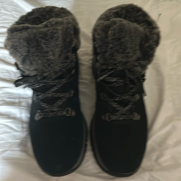 Skechers Shoes - These are Skechers boots. They’re black with grey and white fur on top.